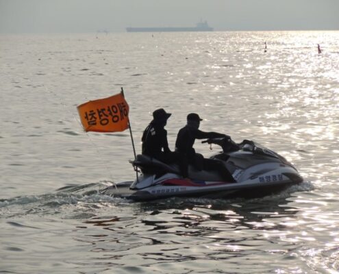 Zwei Polizisten auf einem Wasserscooter auf Jeju, Südkorea