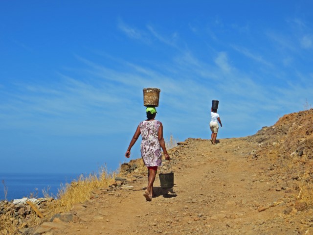 Frauen laufen mit Eimern auf dem Kopf einen steinigen Weg hoch, Santo Antao, Kapverden