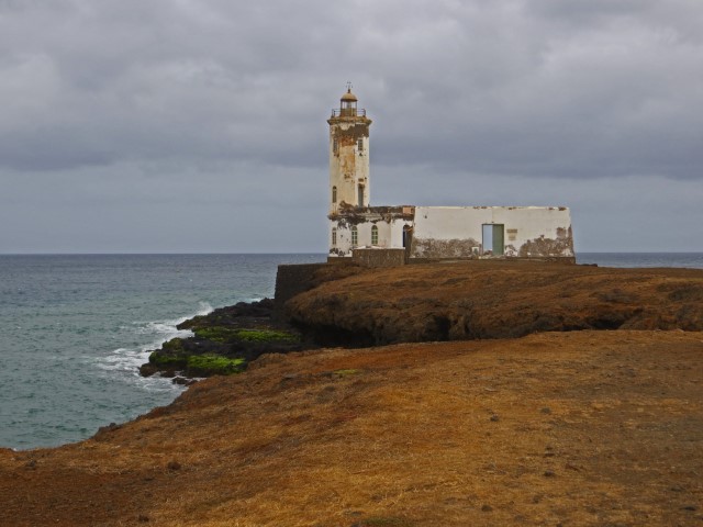 Abblätternder weißer Leuchtturm auf einer trockenen Landspitze auf Praia, Kapverden