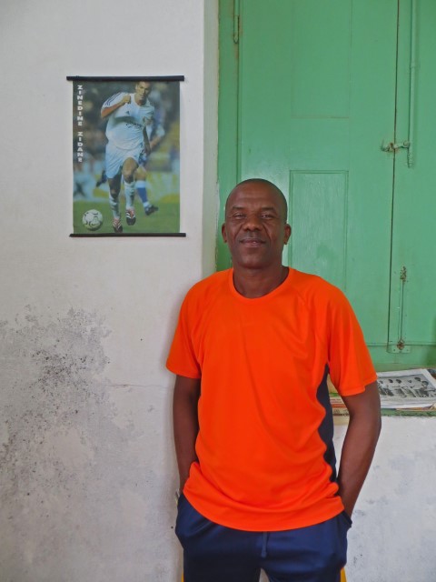 Farbiger Mann Jorge mit orangem T-Shirt vor einem grünen Fensterladen, Praia, Kapverden