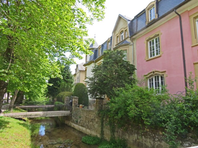 Bunte Häuser mit Wassergräben und kleinen Brücken davor auf dem Weg nach Echternach, Luxemburg