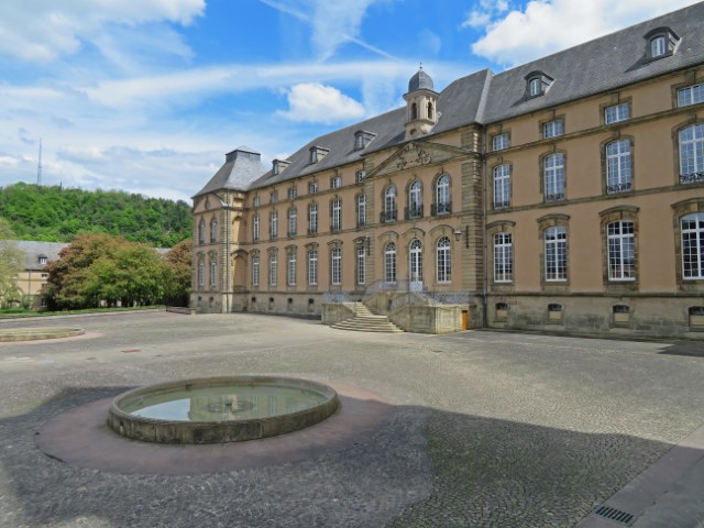 Gelber Römerpalast mit großem Platz und kleinem Brunnen in Echternach, Luxemburg