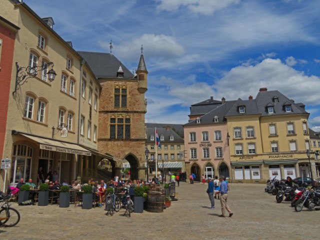 Blick auf den Marktplatz vonEchternach, Luxemburg, mit gelblichen Häusern und einem Erker mit Turm