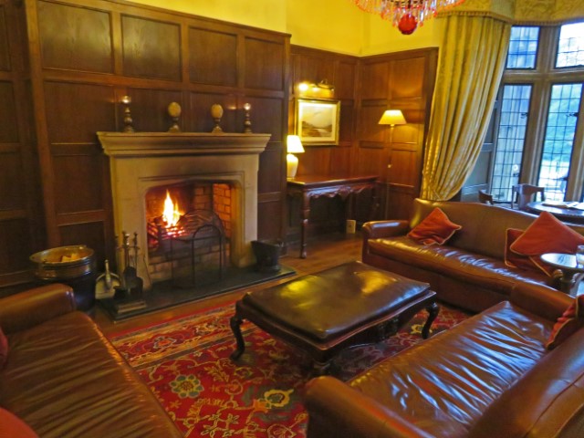 Gemütlicher Wohnraum im Lough Eske Castle in Donegal, Irland mit Ledermöbeln und Feuer im Kamin