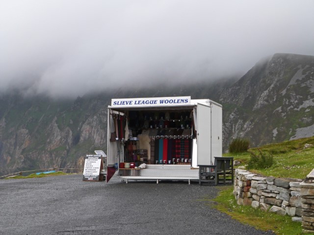 Mobiler Kiosk, der vor dem wolkenverhangenen Slieve League, Donegal, Irland, Wollsachen verkauft