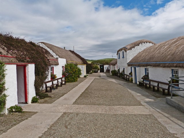 Weiße Häuser mit Reetdach im Doagh Famine Village, Irland