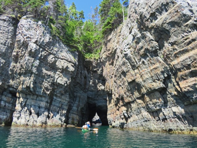 Schmaler Durchbruch in begrünten Felsen, durch den Kajaks fahren, Neufundland