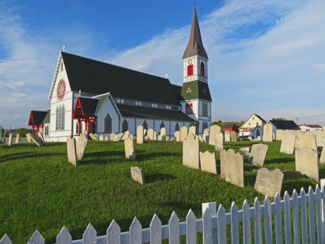 Weiße Holzkirche mit roten Fenstern und schwarzem Dach von Trinity, Neufundland