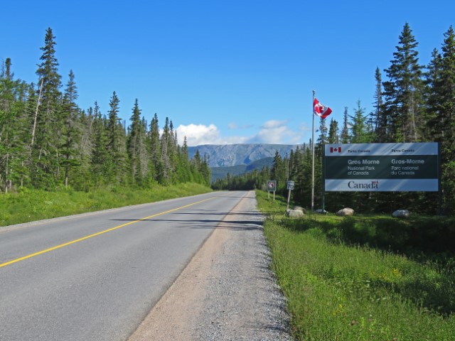 Straße mit Blick auf die Berge und Schild Gros Morne Nationalpark