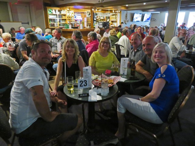 Familie sitzt an einem Tisch in einer vollen Bar im Gros Morne Nationalpark Neufundland