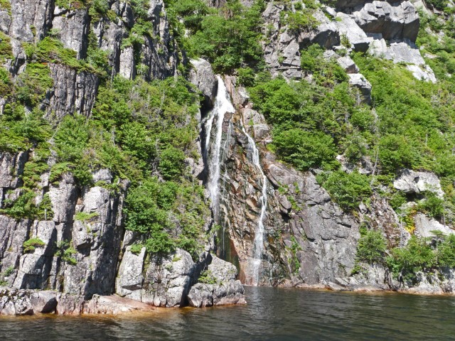 Wasserfall stürzt sich von den Felsen in den Western Brook Pond im Gros Morne Nationalpark Neufundland