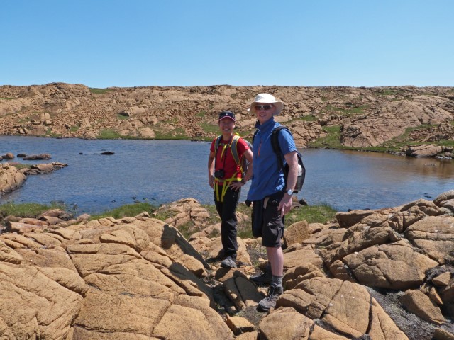 Junges Paar in der Steinwüste an einem See, Gros Morne Nationalpark Neufundland