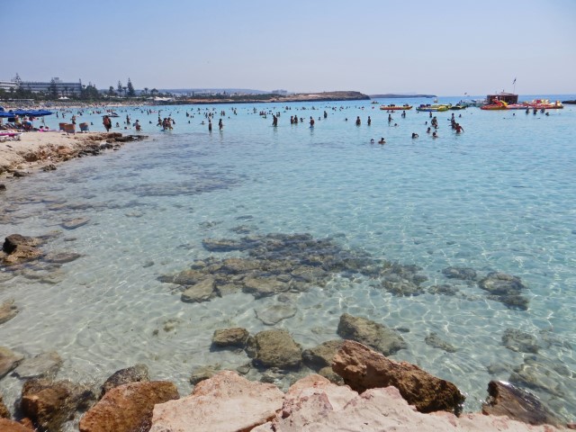 Nissi Beach in Zypern mit türkisfarbenem, flachen Wasser und vielen Touristen