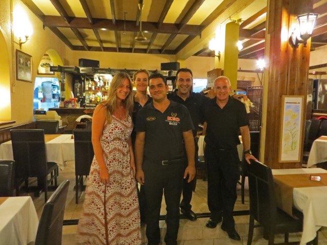 Restaurantcrew und Touristin in langem Kleid