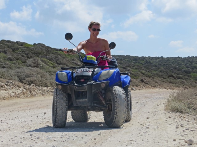 Junge Frau mit Sonnenbrille auf blauem Quad, Zypern