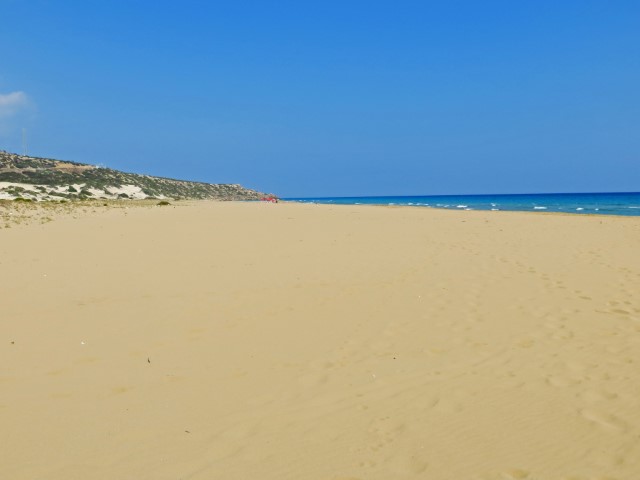 Langer Sandstrand mot blauem Meer auf der Karpaz Halbinsel, Nordzypern