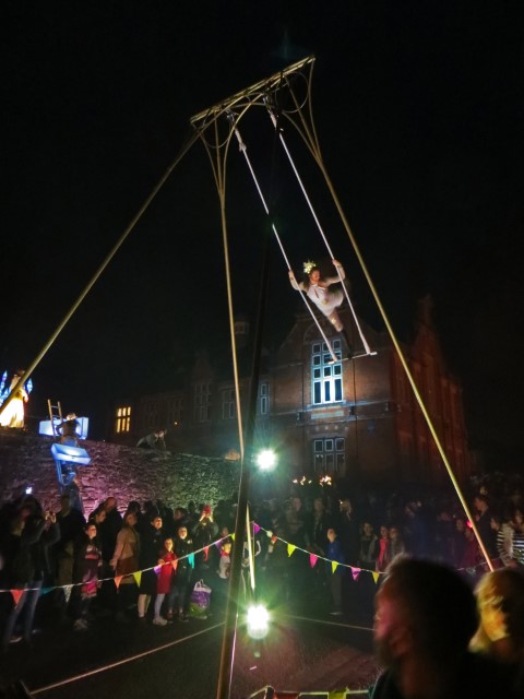 Trapezkünstlerin schingt nachts an Halloween in Derry, Nordirland, auf einem Trapez