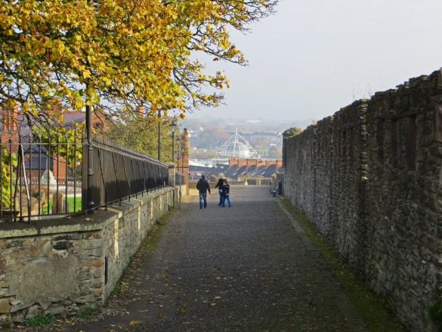 Weg an der alten Stadtmauer von Derry, Nordirland, daneben Bäume in Herbstblättern