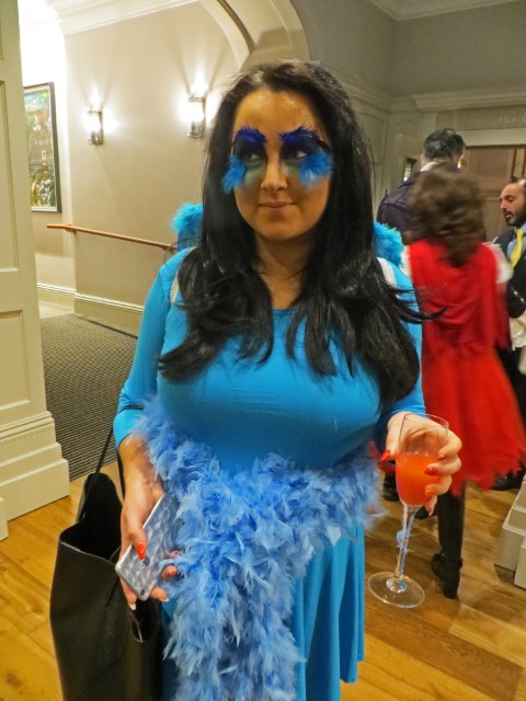 Mädchen verkleidet als Twitter-Bird mit blauem Kleid und Federn an den Wimpern an Halloween in Derry, Nordirland