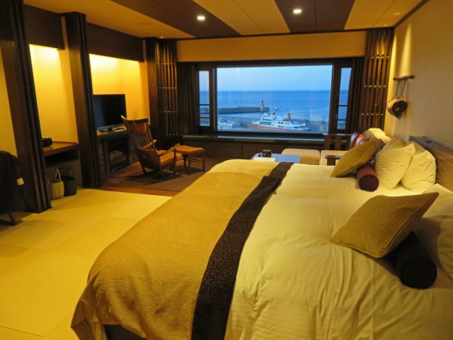 Hotelzimmer mit riesigem Doppelbett und Blick über den Hafen in Utoro, Hokkaido, Japan