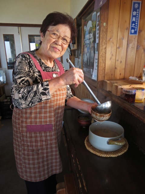 Japanische Gastgeberin füllt zum Frühstück Suppe in Schalen, Hokkaido, Japan