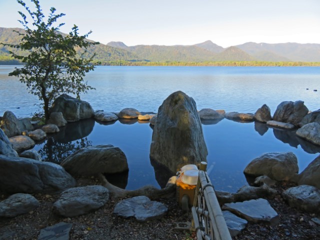 Onsen, von Steinen umgeben, des Ainu-Guesthouses, mit Blick über den See