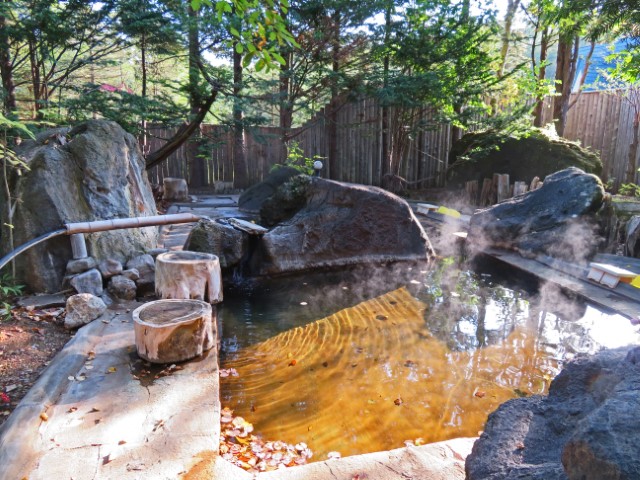 Kleiner Onsen, von Steinen umgeben, im Garten der Unterkunft, Hokkaido, Japan