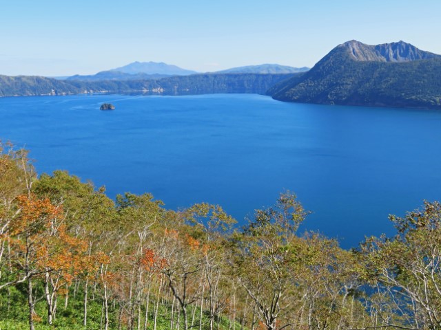 Blick über den blauen Mashu See mit Bergen im Hintergrund, Hokkaido, Japan