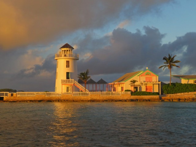 Von der Abendsonne beleuchteter weißer Leuchtturm und Holzhaus auf Pearl Island