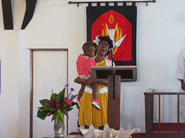 Sängerin in einer Kirche in Nassau mit Kleinkind auf dem Arm