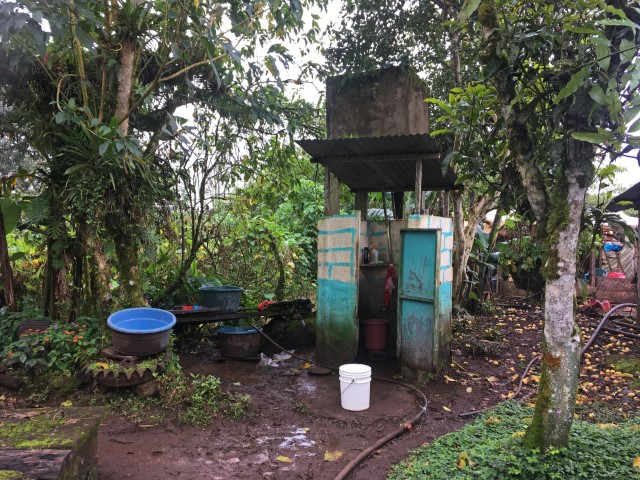 Einfache Dusche mit Steinwänden und Bottich darüber