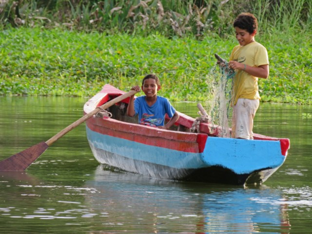 Zwei Kinder mit Fischernetz fahren auf einem Boot auf dem Nicaraguasee