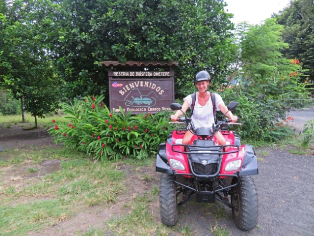 Junge Frau mit Helm auf rotem Quad auf Ometepe in Nicaragua