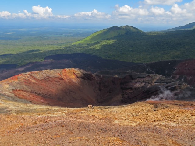 Blick vom Cerro Negro über die vulkanische und grüne Landschaft und einen Krater