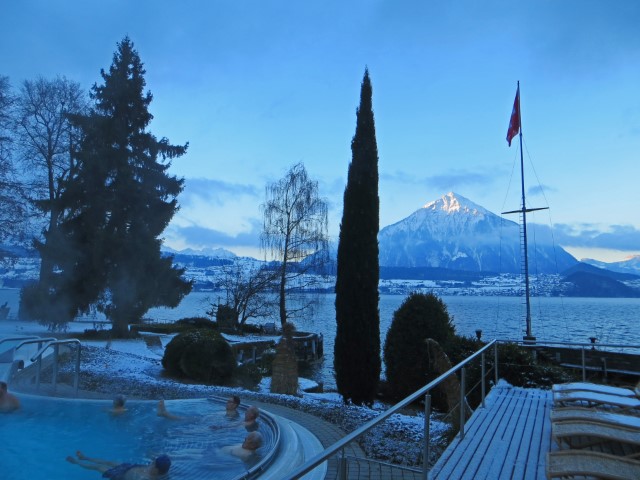 Menschen liegen in heißem Solbad im Beatus Hotel, im Hintergrund der See und die Berge