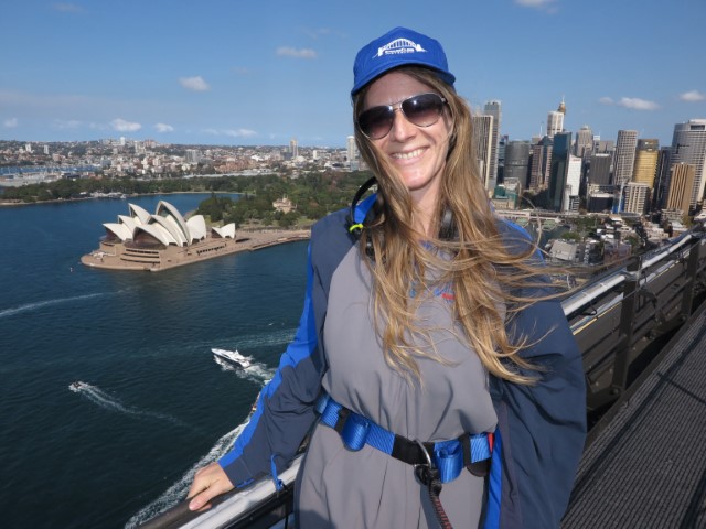 Junge Frau in grauem Anzug mit Sonnenbrille beim Sydney Bridge Climb