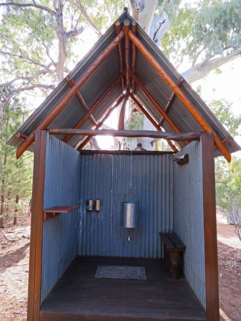 Provisorische Dusche in einer offenen Hütte im Elder Camp