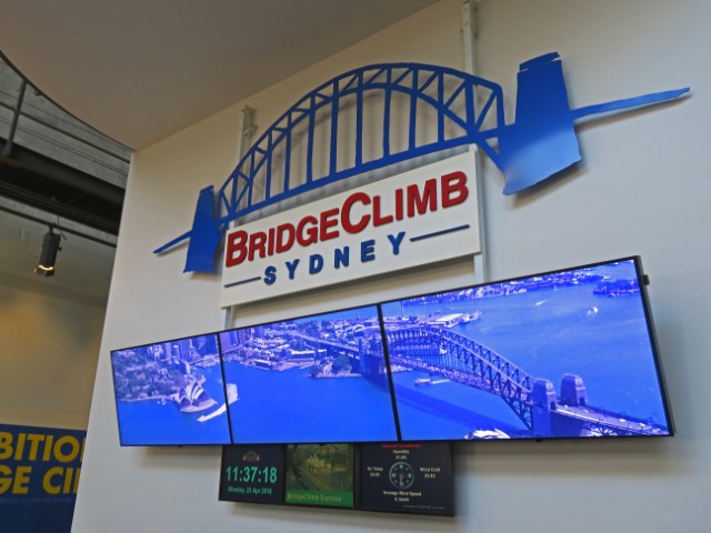 Schild mit Bridge Climb Sydney und Bild darunter