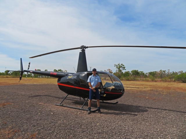 Schwarzer Hubschrauber mit Pilot davor