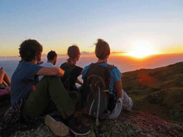 Touristen bestaunen Sonnenuntergang auf Wayasewa von einem Hügel aus