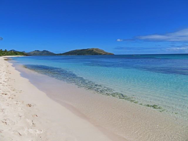 Weißer Sandstrand vor klarem türkisfarbenen Wasser auf Nacula Island