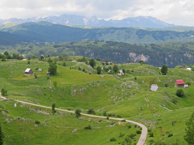 Grüne Berglandschaft mit Berghäusern am Durmitor-Ring