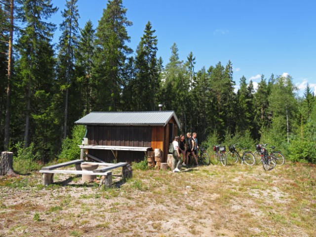 Holzhütte vor dichtem Wald