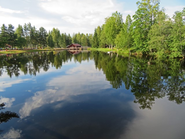 See in Mångberg umgeben von grünen Bäumen