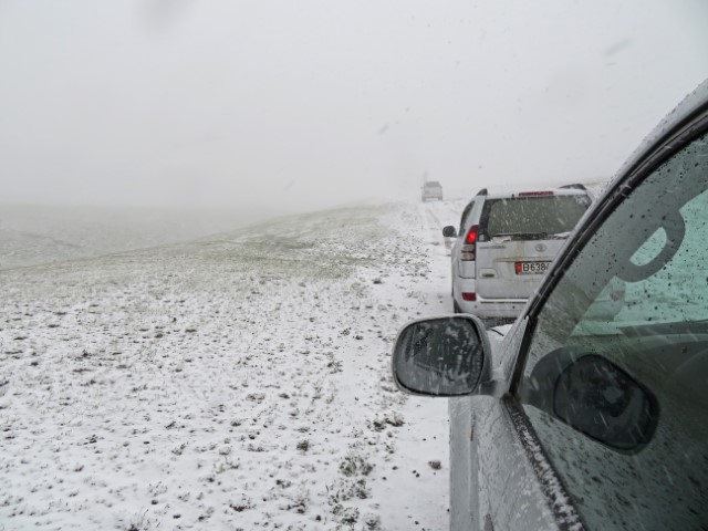 Geländewagen fahren im Schnee durchs Tien Shan Gebirge Kirgistans