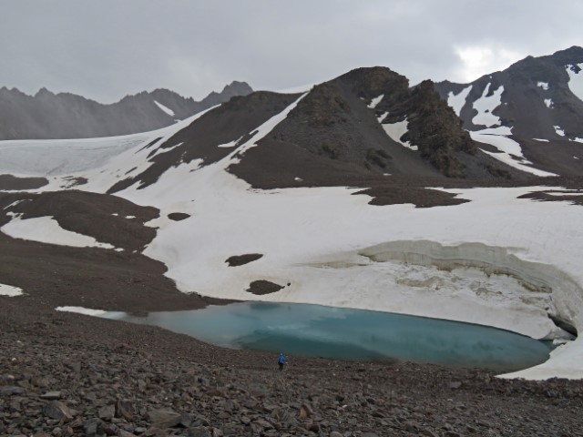 Blauer Bergsee vor schneebedeckten Gipfeln im Tien Shan Gebirge Kirgistans