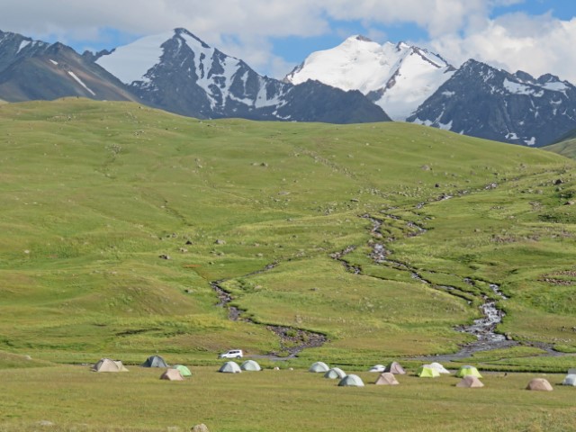 Zeltlager in den Tien Shan Gebirge Kirgistans mit schneebedeckten Gipfln im Hintergrund