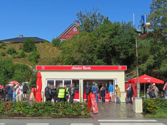 Blick auf Annies Kiosk mit einer Schlange Menschen davor