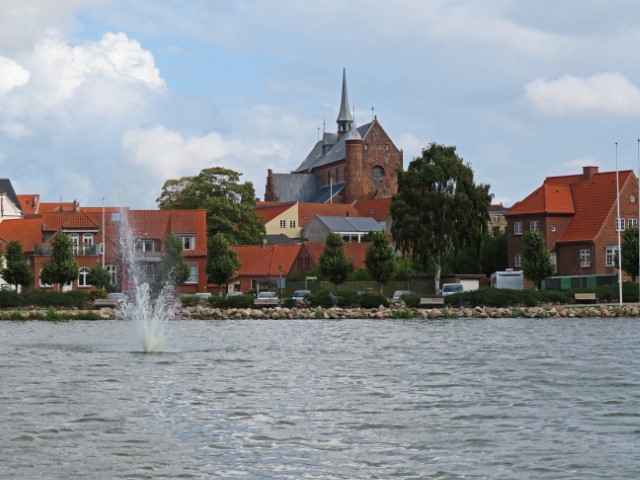 Blick übers Wasser mit Fontäne auf die Kirche und Häuser von Haderslev