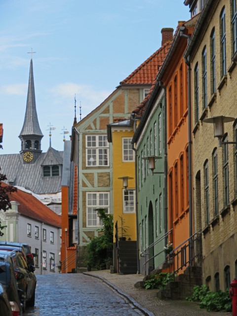 Bunte Häuser und Blick auf einen Kirchturm in Haderslev